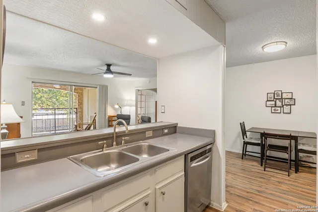 a kitchen with a sink and wooden floor