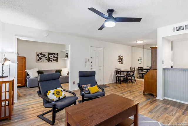 a living room with furniture a rug and kitchen view