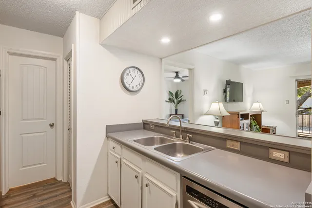 a kitchen with a sink and a clock