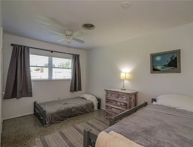 a bedroom with a bed a dresser next to a window