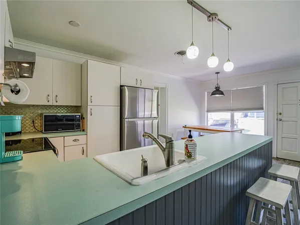 a kitchen with sink cabinets and refrigerator