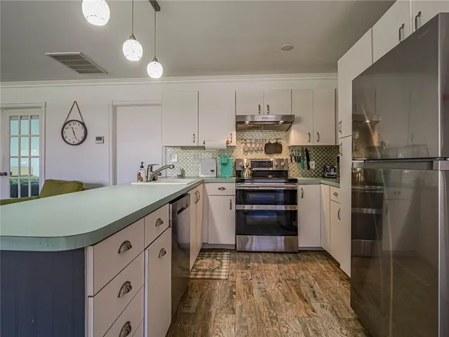 a kitchen with kitchen island white cabinets and stainless steel appliances