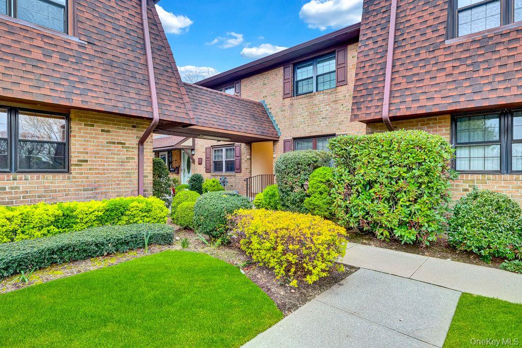 a front view of a house with a garden and plants