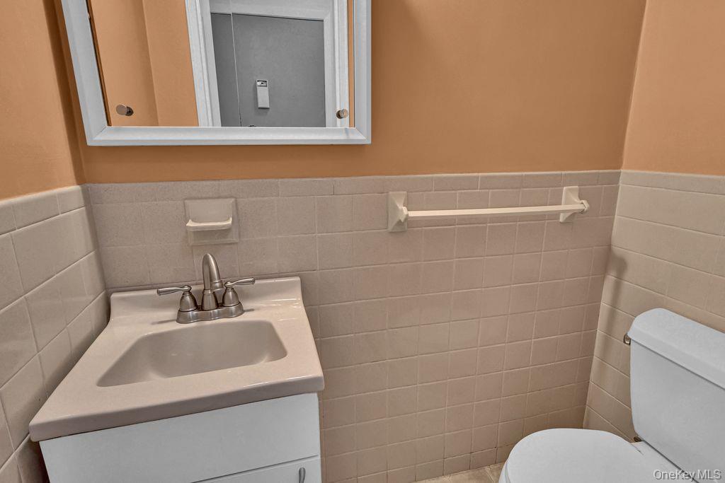 311 Mariners Way Copiague, NY 11726 - Photo 11 of 21 a bathroom with a sink a toilet and mirror