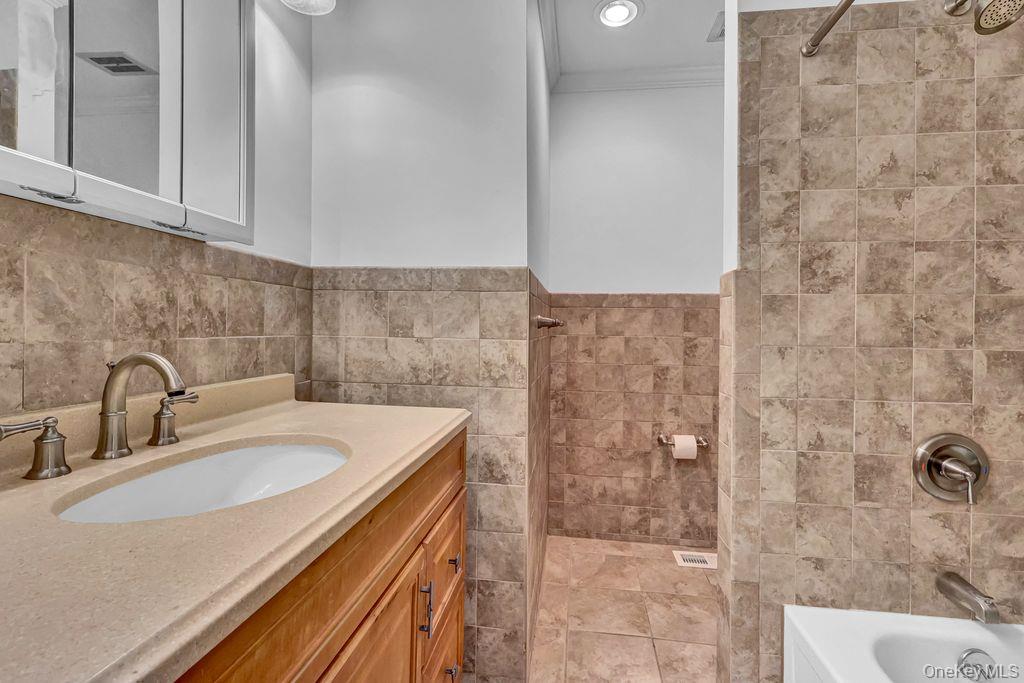 311 Mariners Way Copiague, NY 11726 - Photo 13 of 21 a bathroom with a sink a vanity and shower