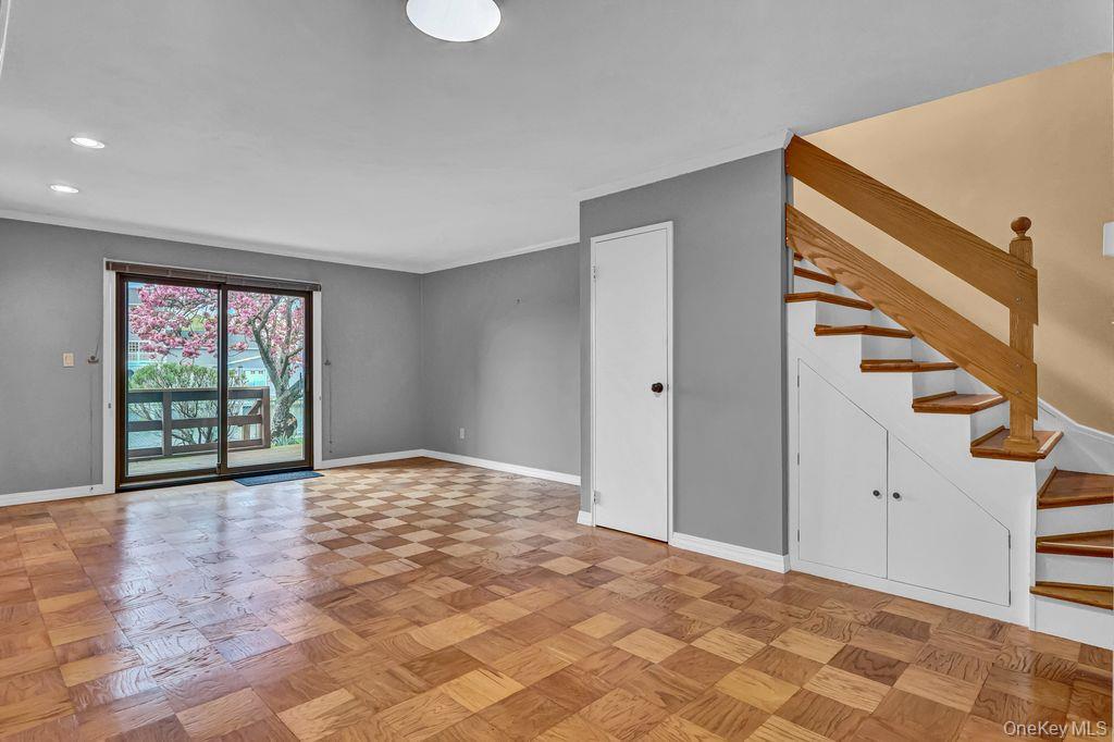 311 Mariners Way Copiague, NY 11726 - Photo 3 of 21 a view of an empty room with wooden floor and windows