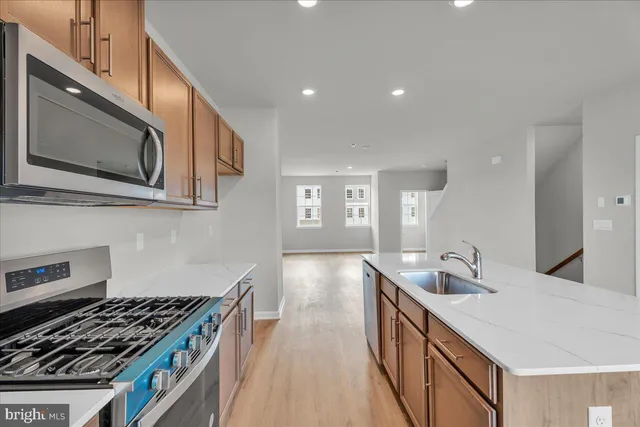 a kitchen with cabinets stainless steel appliances and a sink