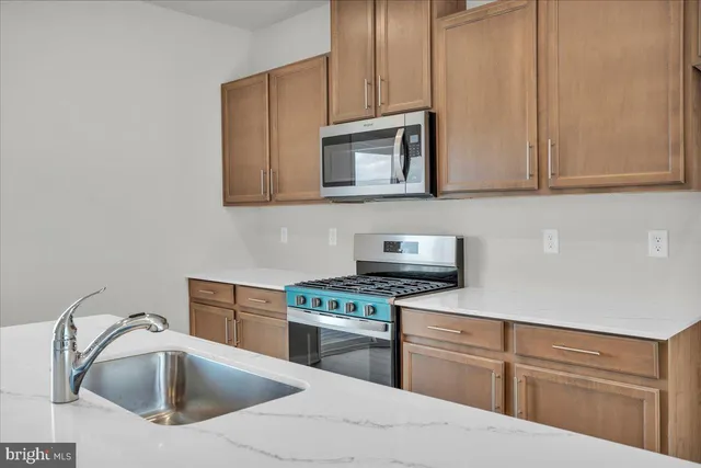 a kitchen with stainless steel appliances kitchen island wooden cabinets and wooden floor