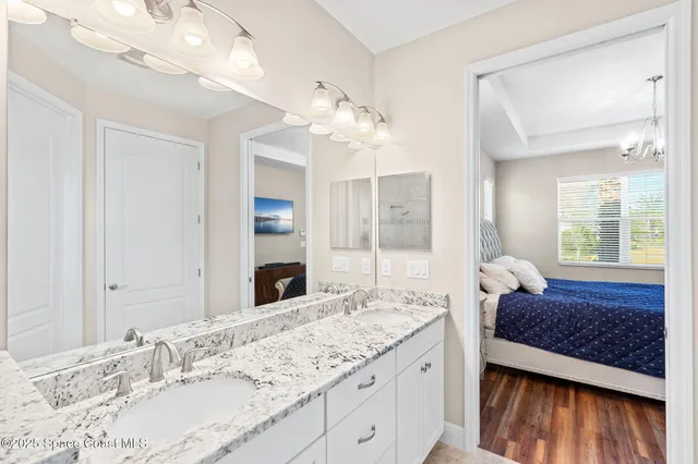 a en suite bathroom with a granite countertop sink and a mirror