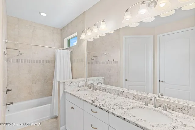 a bathroom with a granite countertop sink a toilet and shower