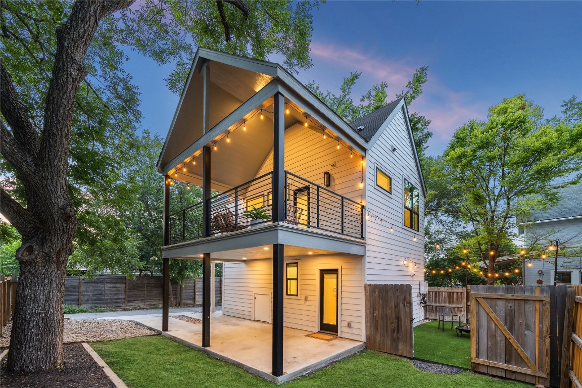 Rear view of property featuring a balcony, a patio, and a fenced backyard