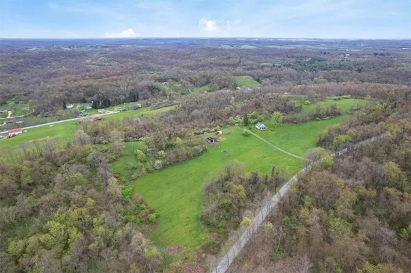 an aerial view of a houses with outdoor space and trees