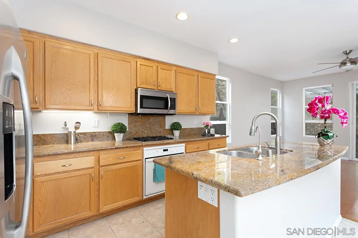 12253 Pepper Tree Lane Poway, CA 92064 - Photo 7 of 39 a kitchen with granite countertop a sink stainless steel appliances and cabinets