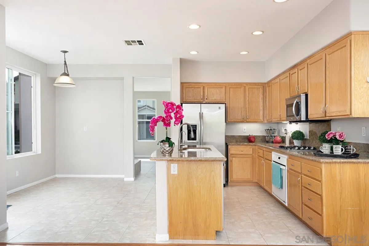 12253 Pepper Tree Lane Poway, CA 92064 - Photo 9 of 39 a kitchen with stainless steel appliances granite countertop a sink stove and refrigerator