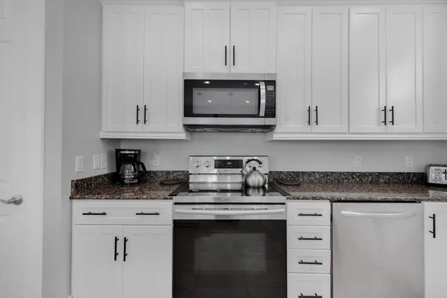 a bathroom with a granite countertop double vanity sink mirror and toilet