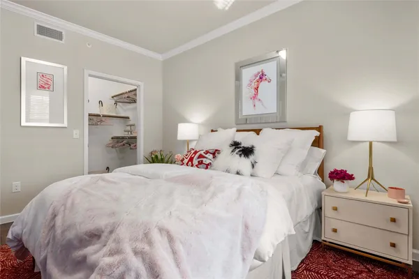 a bedroom with a bed and a lamp on dresser