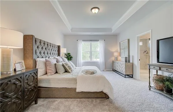 a spacious bedroom with a bed a couch and dresser