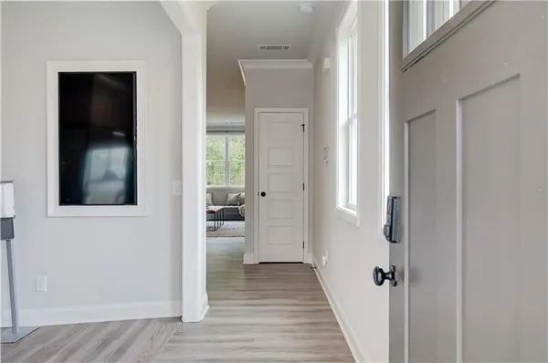a view of a hallway with a dining room and wooden floor