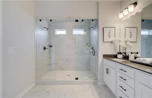 a bathroom with a double vanity sink and mirror with shower