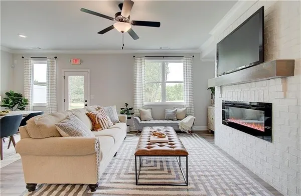 a living room with furniture a flat screen tv and a fireplace