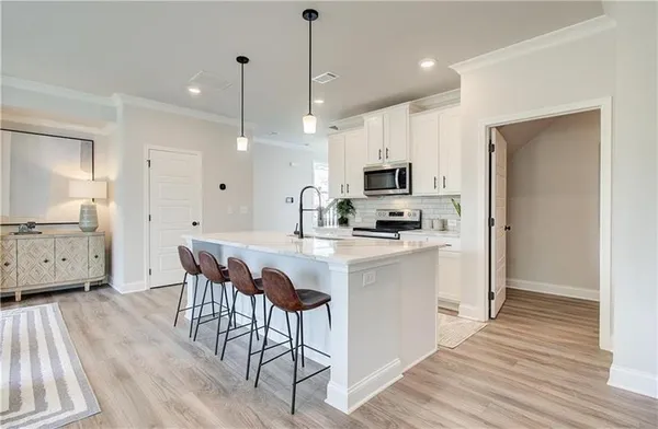 a kitchen with kitchen island granite countertop a sink cabinets and wooden floor
