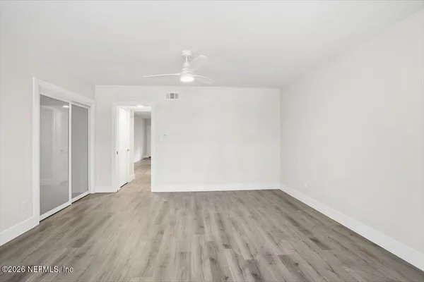 a view of a room with wooden floor and white walls
