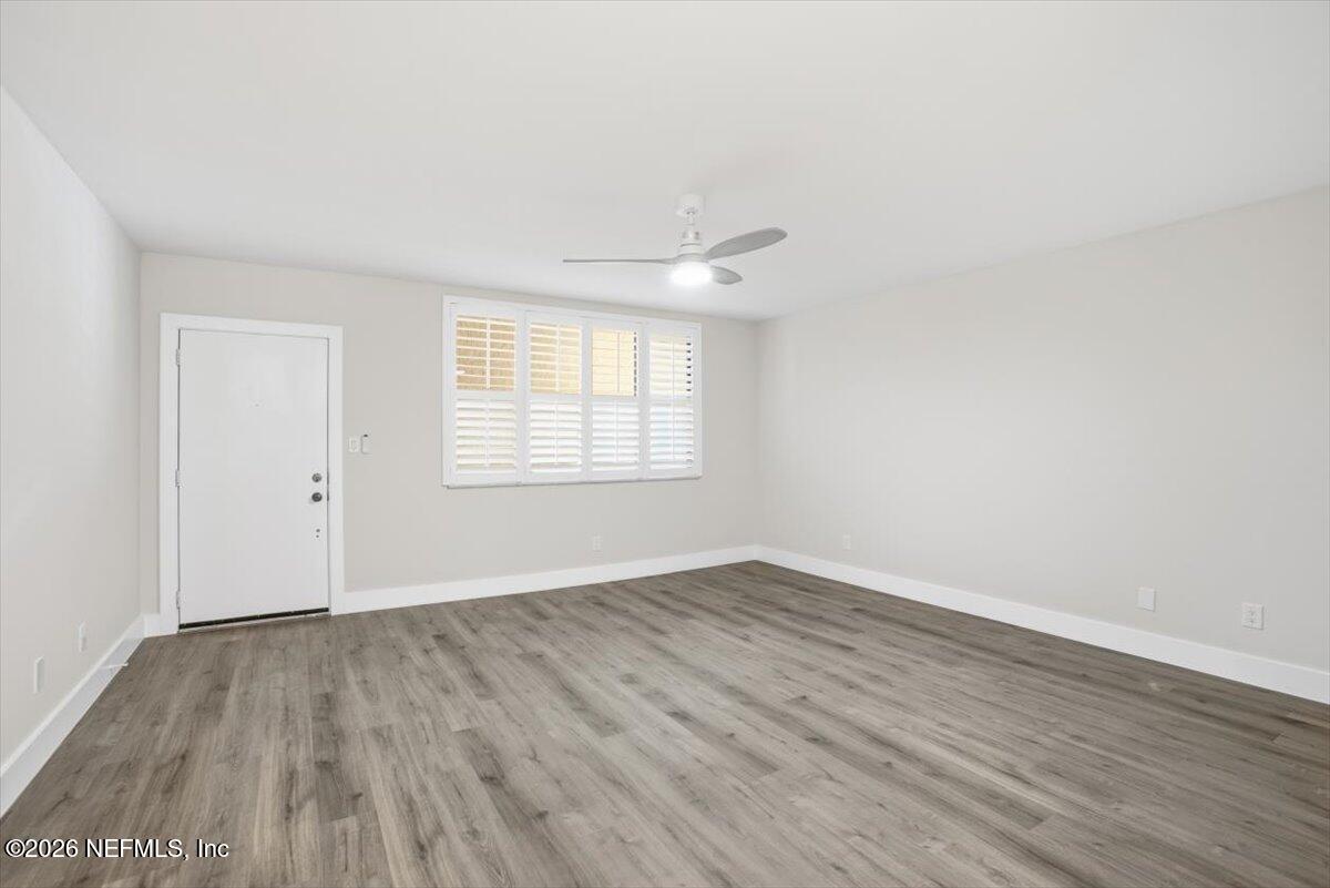 1810 Sevilla Boulevard West, Unit 310 Atlantic Beach, FL 32233 - Photo 4 of 18 an empty room with wooden floor and windows