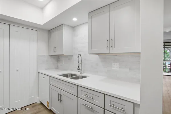 a kitchen with white cabinets and a sink