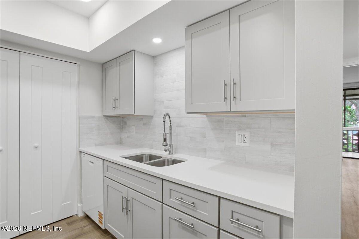 1810 Sevilla Boulevard West, Unit 310 Atlantic Beach, FL 32233 - Photo 7 of 18 a kitchen with white cabinets and a sink