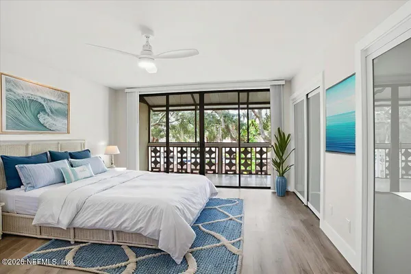 a bedroom with a balcony a bed and a large window