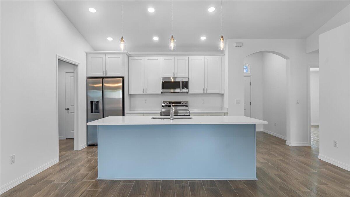 1938 Jupiter Boulevard Southwest Palm Bay, FL 32908 - Photo 11 of 41 a large kitchen with stainless steel appliances granite countertop a sink a stove a refrigerator and a microwave