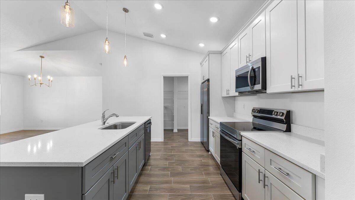 1938 Jupiter Boulevard Southwest Palm Bay, FL 32908 - Photo 12 of 41 a kitchen with stainless steel appliances granite countertop a sink and a stove top oven