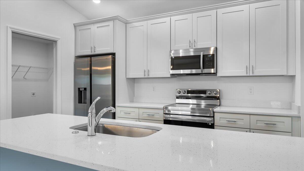1938 Jupiter Boulevard Southwest Palm Bay, FL 32908 - Photo 13 of 41 a kitchen with stainless steel appliances granite countertop a sink a stove and a microwave