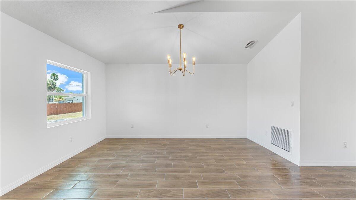 1938 Jupiter Boulevard Southwest Palm Bay, FL 32908 - Photo 17 of 41 wooden floor in an empty room with a window