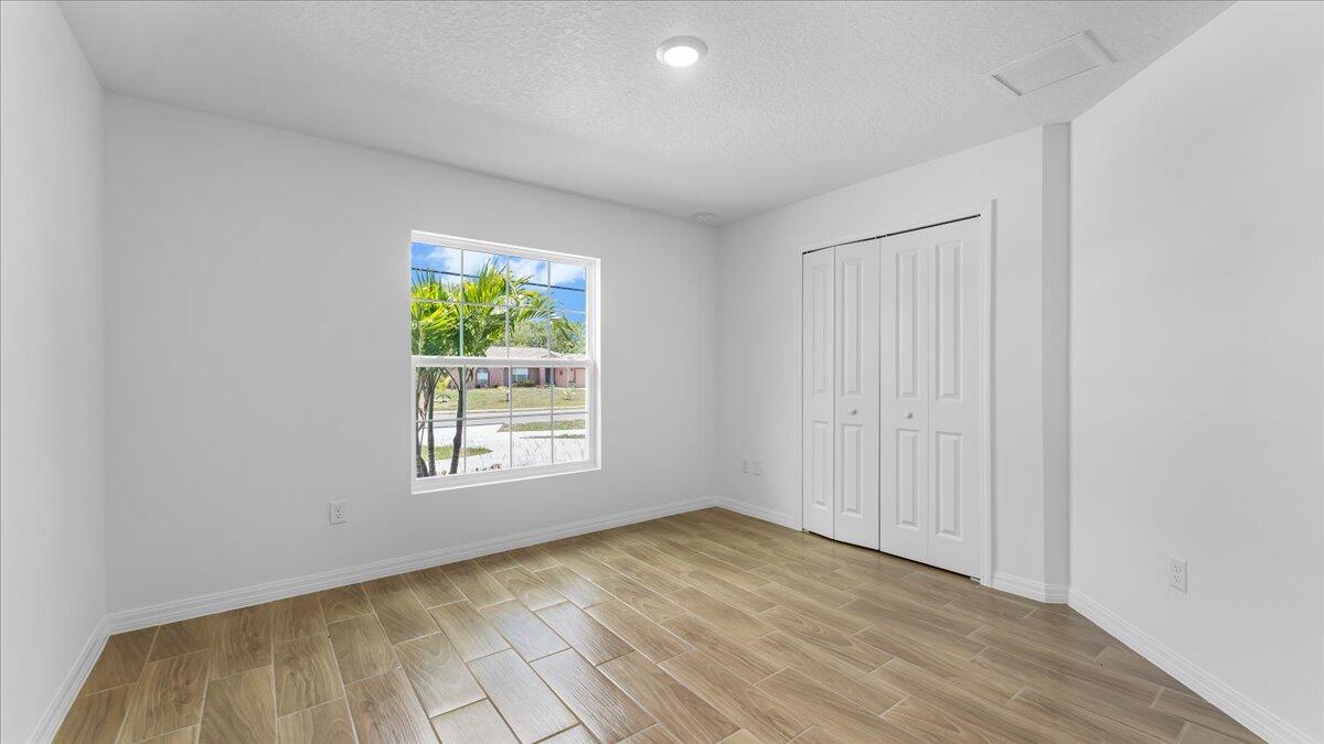 1938 Jupiter Boulevard Southwest Palm Bay, FL 32908 - Photo 23 of 41 a view of empty room with wooden floor and fan