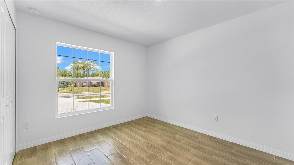 1938 Jupiter Boulevard Southwest Palm Bay, FL 32908 - Photo 27 of 41 a view of an empty room with wooden floor and a window