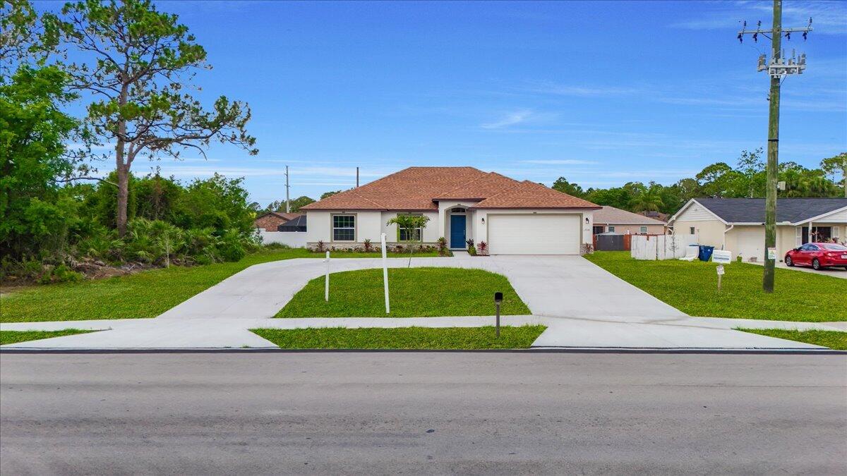 1938 Jupiter Boulevard Southwest Palm Bay, FL 32908 - Photo 31 of 41 a green and white house with a yard and plants