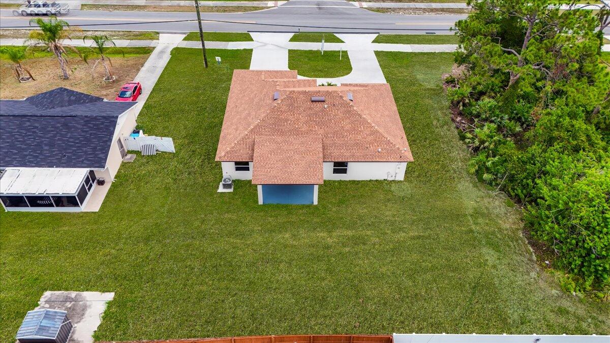 1938 Jupiter Boulevard Southwest Palm Bay, FL 32908 - Photo 34 of 41 a backyard of a house with plants and large trees