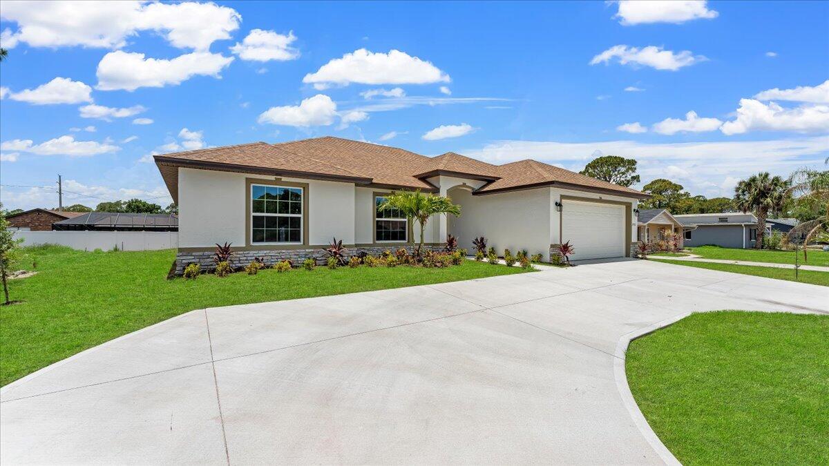1938 Jupiter Boulevard Southwest Palm Bay, FL 32908 - Photo 5 of 41 a front view of a house with a yard and garage