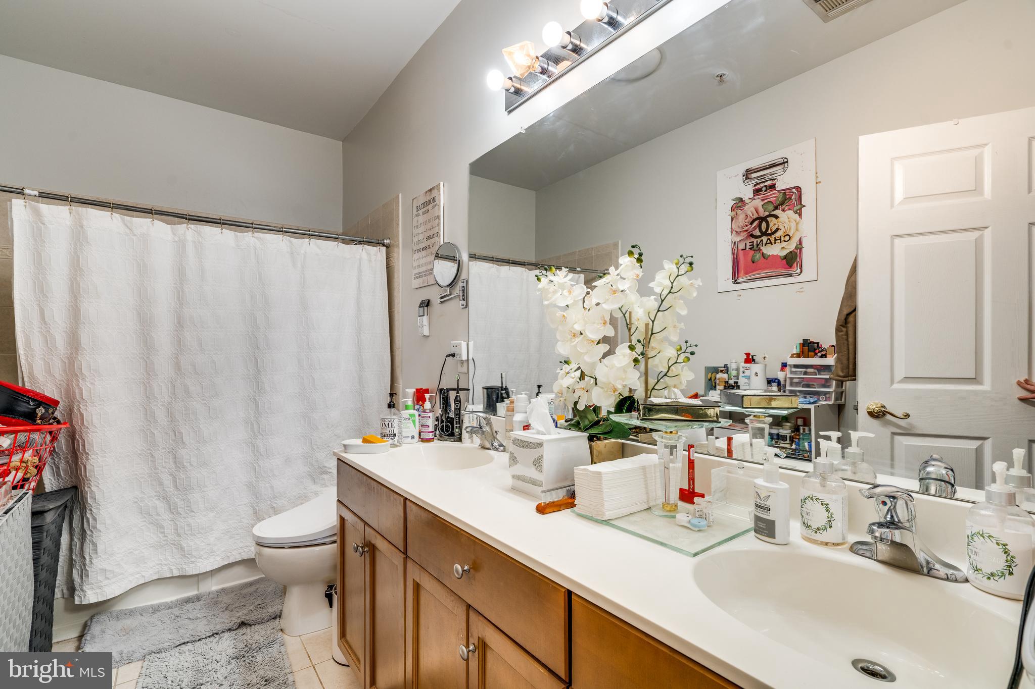 235 Masterson Court Ewing, NJ 08618 - Photo 14 of 19 a bathroom with double vanity sinks a toilet a mirror and shower curtain