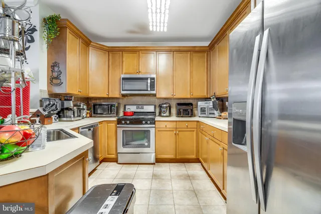 a kitchen with stainless steel appliances granite countertop a stove a sink and a refrigerator