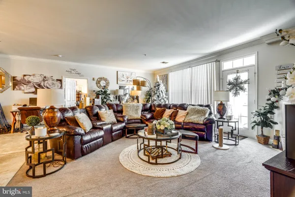 a living room with furniture kitchen view and a window