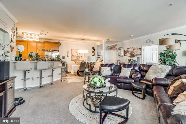 a living room with furniture kitchen view and a large window