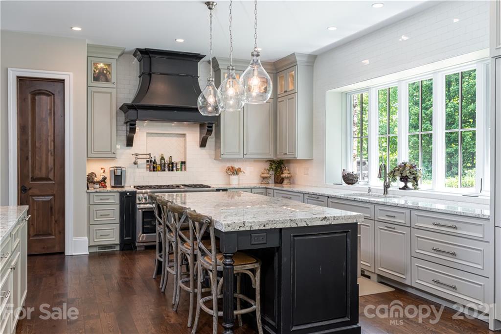 301 Flying Dutchman Road Sylva, NC 28779 - Photo 22 of 48 a kitchen with stainless steel appliances granite countertop a stove a refrigerator a sink dishwasher a dining table and chairs with wooden floor