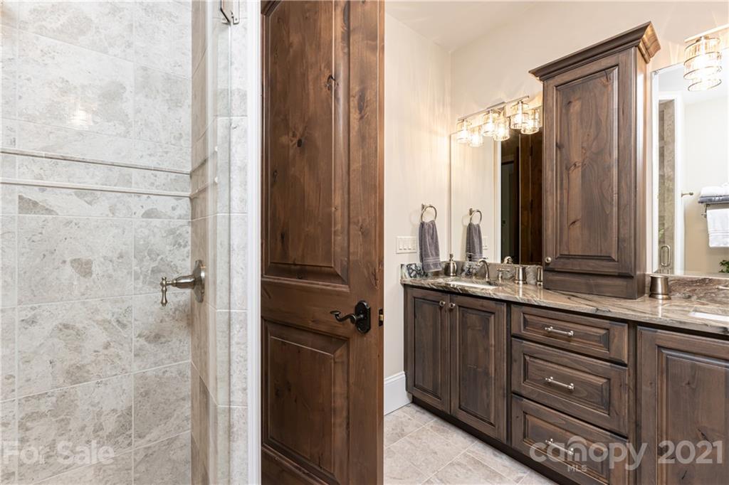 301 Flying Dutchman Road Sylva, NC 28779 - Photo 39 of 48 a bathroom with a granite countertop sink a mirror and a shower