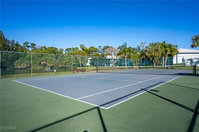 a view of a swimming pool with lawn chairs under an umbrella