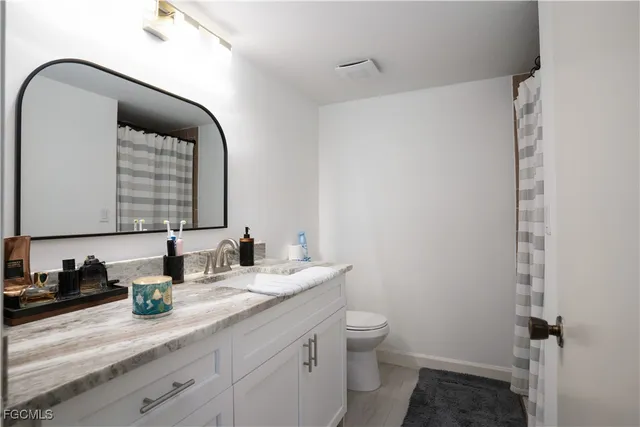 a bedroom with a bed and a flat tv screen on dresser