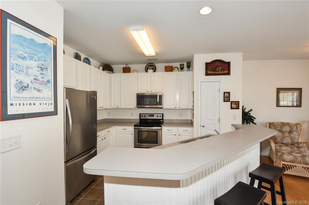 822 Gentlewinds Court, Unit 143 Fort Mill, SC 29708 - Photo 12 of 21 a kitchen with stainless steel appliances kitchen island granite countertop a refrigerator a stove a microwave oven a sink with island and chairs