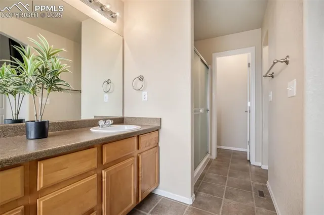 a bathroom with a granite countertop sink a mirror a vanity and a shower