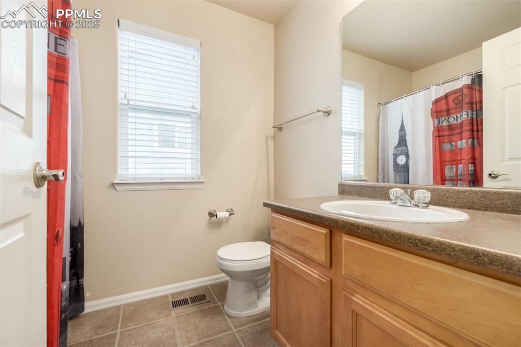 4966 Spokane Way Colorado Springs, CO 80911 - Photo 18 of 35 a bathroom with a granite countertop sink a toilet and a mirror